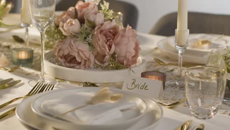 close up of table set for meal at wedding reception with place card for bride