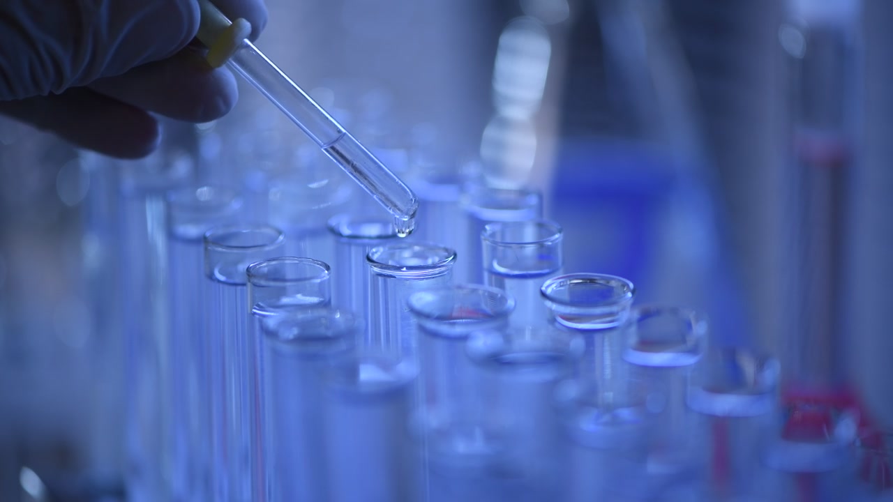 Scientist Dropping Liquid into Test Tube in Laboratory