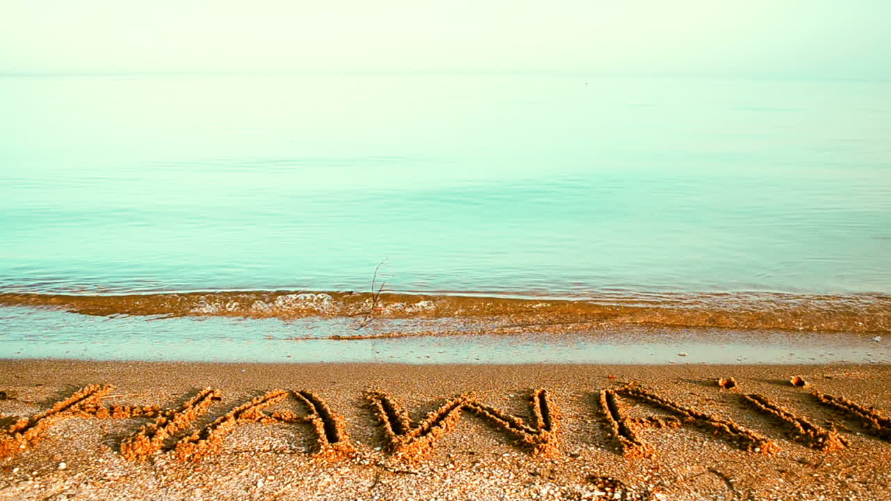 Inscription "Hawaii" made on beautiful beach. Inscription on sand, the beach