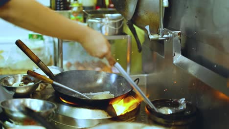 Chef skillfully cooks with a wok in kitchen