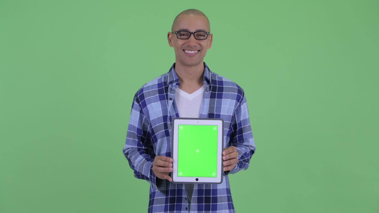 feliz hombre calvo hipster feliz pensando mientras muestra la tableta digital