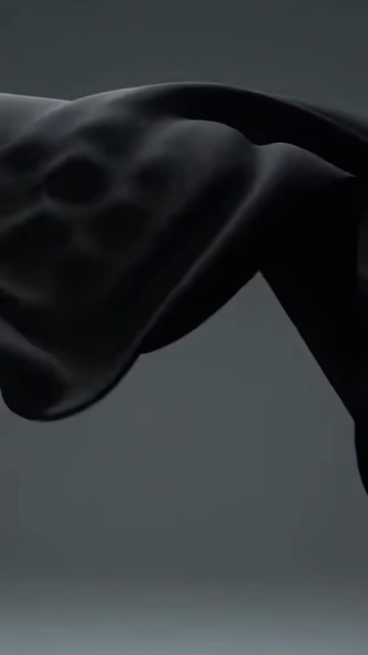 Video dinamico di un tessuto nero fluttuante, ripreso da un'angolazione bassa su uno sfondo scuro.