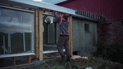 skilled man is constructing a hothouse in its backyard