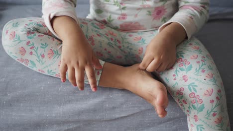 niño sentado en una cama con pijama floral