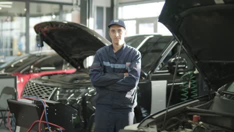 confident auto mechanic in repair workshop