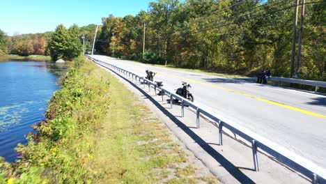 motorbikes parked on roadside while two bikers resting on road trip