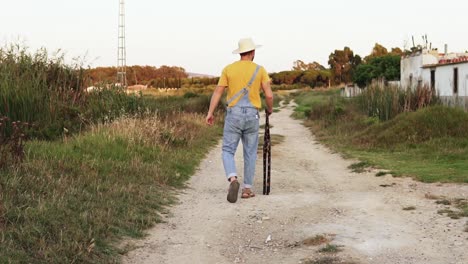 Farmer-man-with-a-hat-walking-in-slow-motion-throughout-his-farm