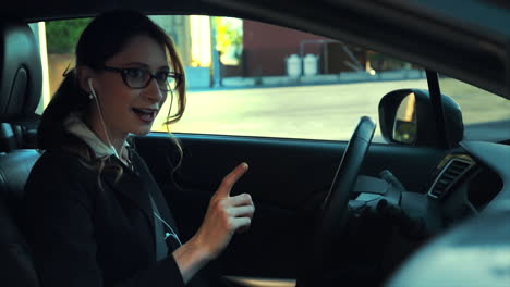 attractive caucasian business woman in a parked car while talking on the phone through her headphones