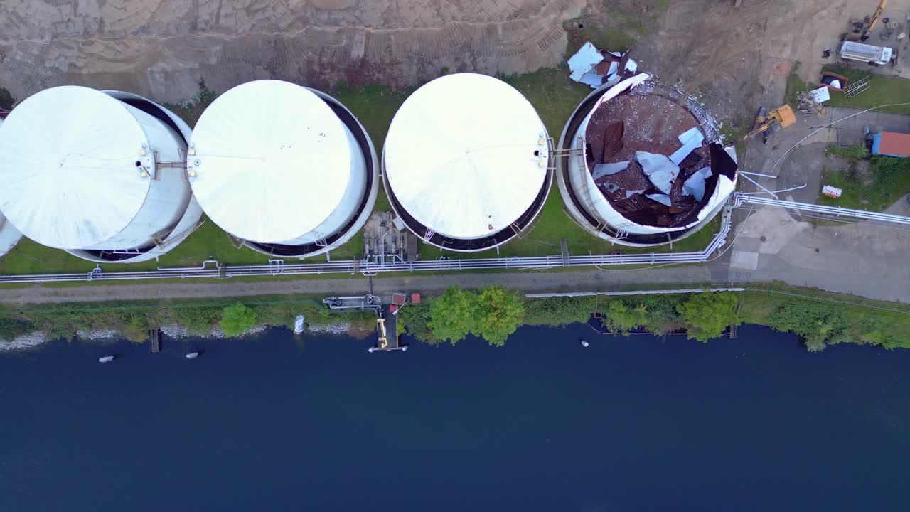 bird's eye view drone of a Demolition Decommissioning Industrial storage tanks holding oil and gas products next to a busy construction area. Nice aerial view flight drone shot from above