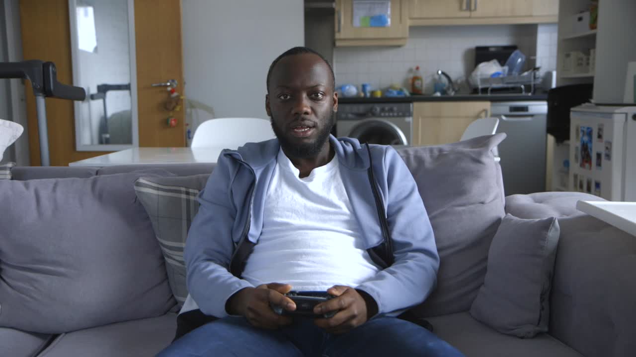 Black Male Competitively Playing Video Games In Lounge Room