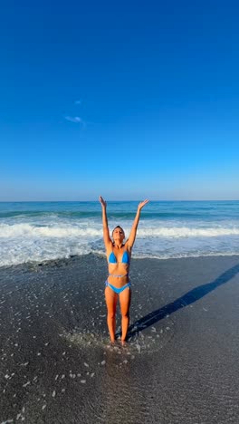 mujer meditando en una playa en un bikini azul
