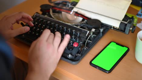 on a typewriter, something is typed off a cell phone while the cell phone has a green screen