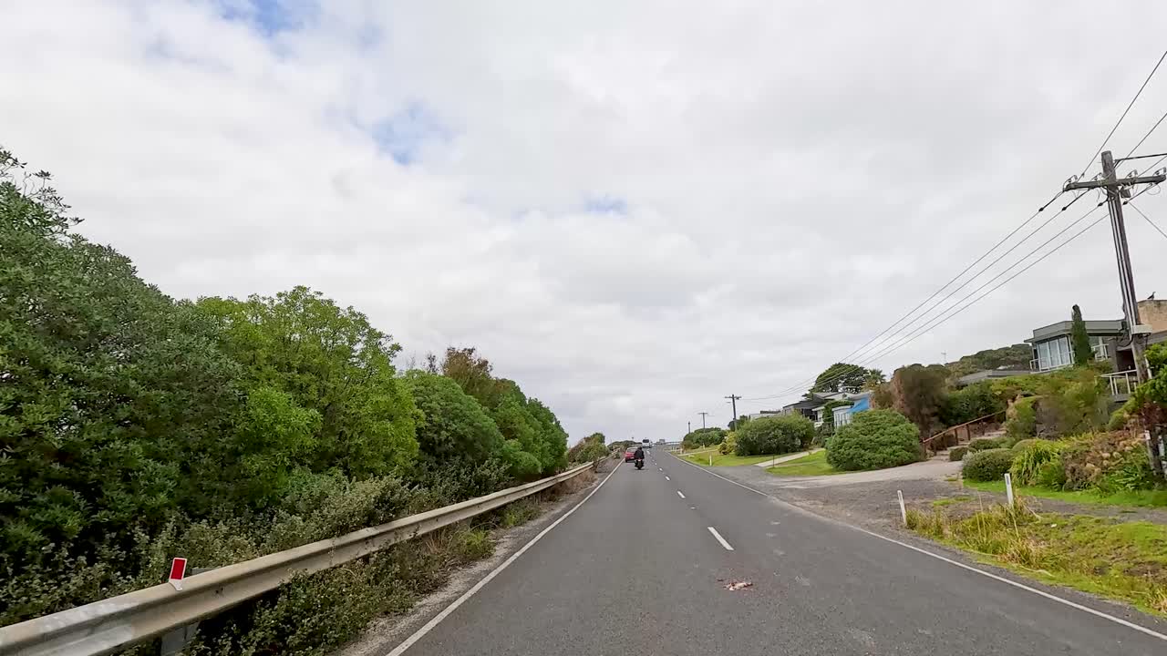 A 14-second video captures a drive along the Great Ocean Road, showcasing coastal views, greenery, and overcast skies