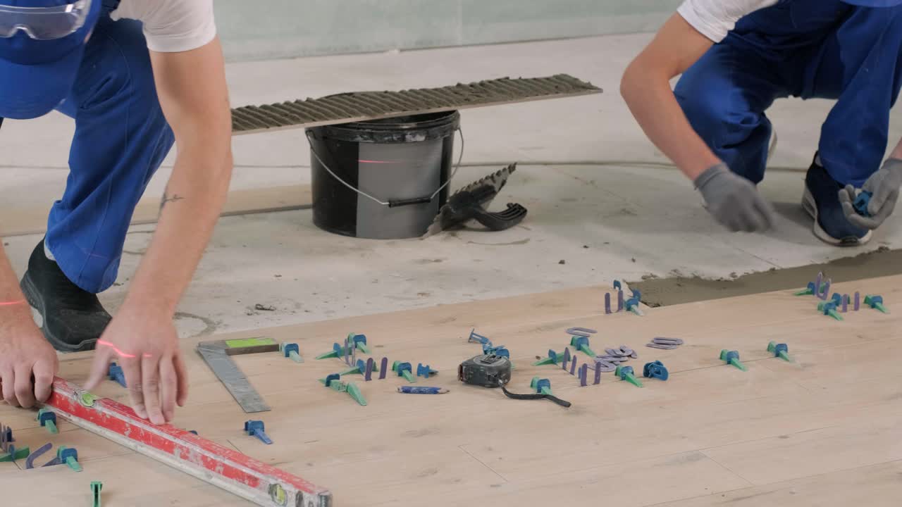 Construction, renovation, repair apartment. Installing ceramic floor tiles - measuring and cutting the pieces. Cuts tile. Tile cutting