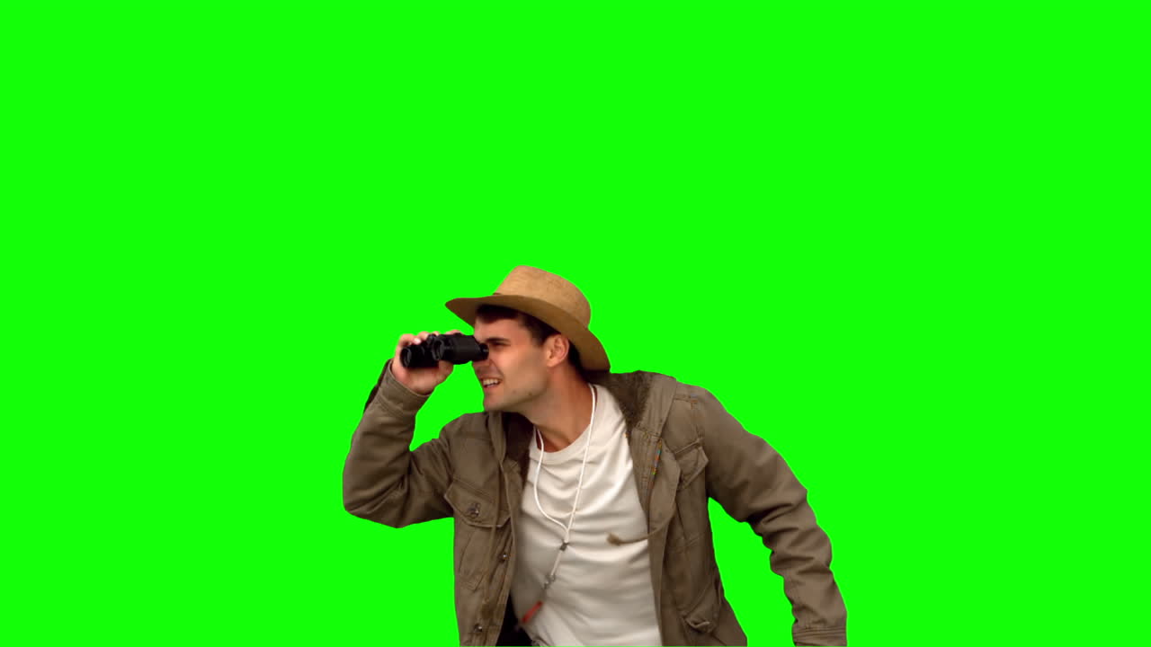 Uomo che salta e usa il binocolo su schermo verde