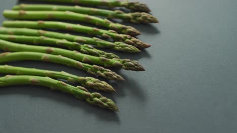 video of fresh asparagus with copy space over grey background