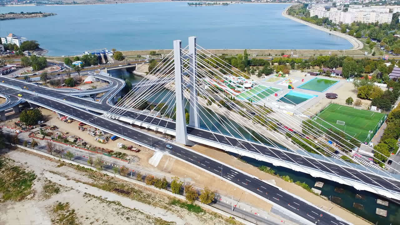 Ciurel passage, bridge over a river with moving cars, recreational complex, lake. View from the drone. Bucharest, Romania