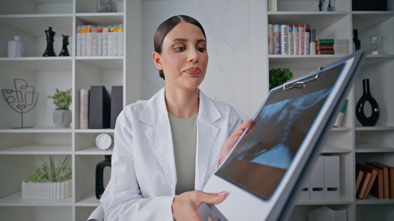 Doctor presenting x-ray online in clinic closeup pov video. Woman radiologist