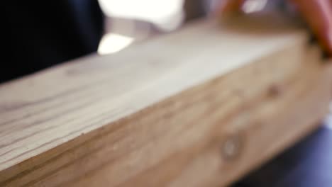 sliding a piece of lumber across a table in slow motion