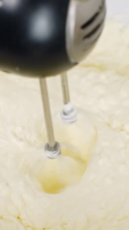 close-up vertical shot of creamy tiramisu being mixed for dessert preparation in the kitchen.