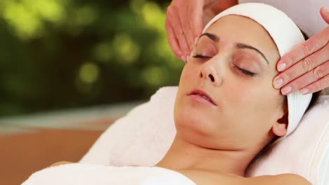 bonita morena recibiendo un masaje facial
