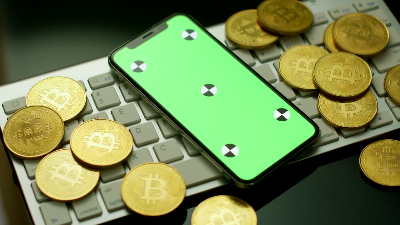 teléfono con pantalla verde y bitcoins