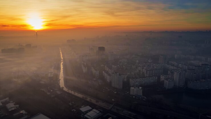 Vista aérea em timelapse de drone de Chisinau ao nascer do sol, Moldávia. Vista da cidade com neblina no ar, vários edifícios, estradas, lago e árvores nuas