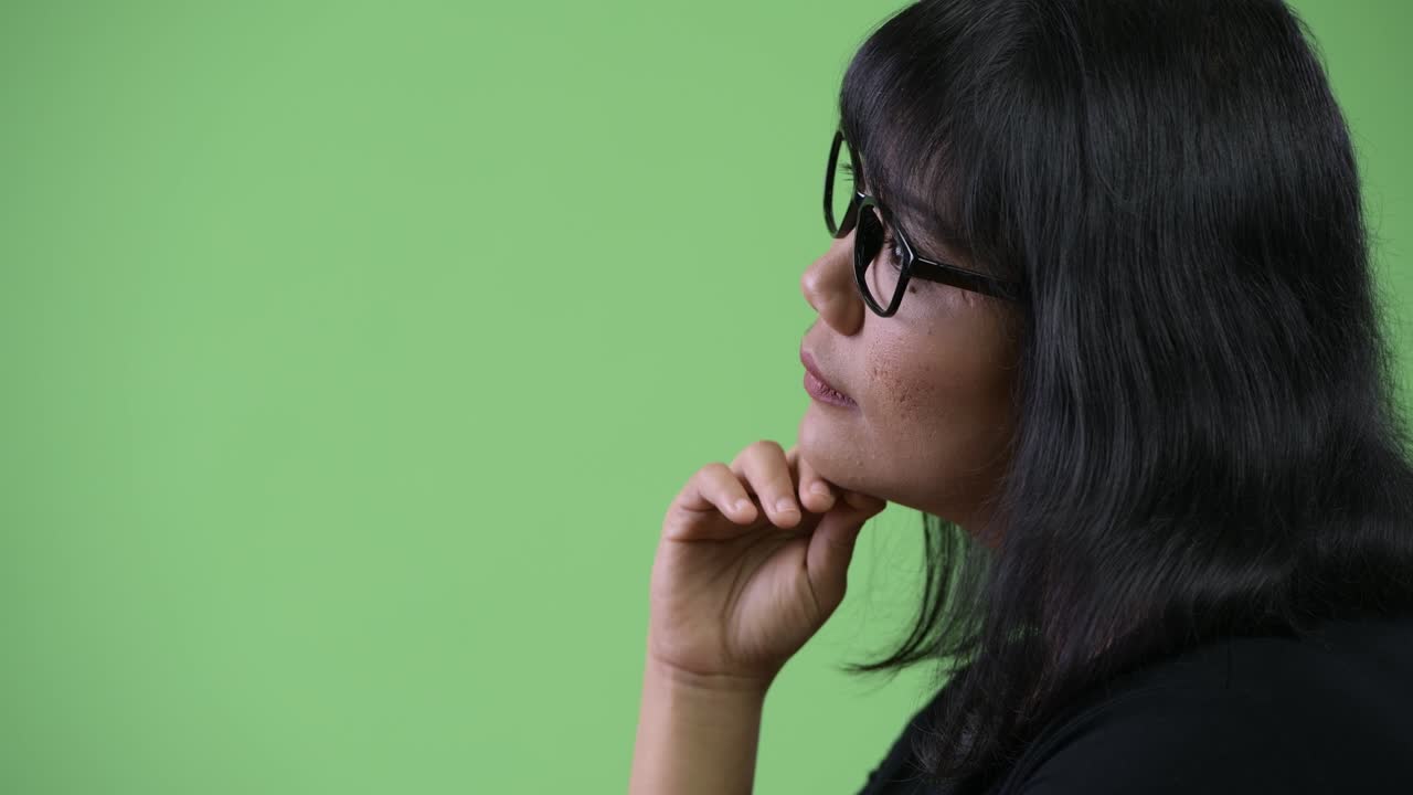 Profile view of beautiful Asian businesswoman thinking