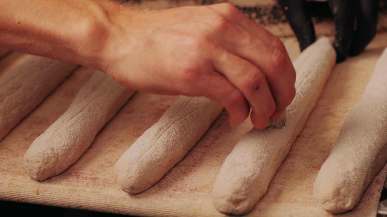 Primo piano di un panettiere che prepara panini artigianali e baguette freschi usando una ricetta tradizionale. Giovane uomo che impasta l'impasto. Il pane artigianale è prodotto da panettieri esperti utilizzando ingredienti naturali e di alta qualità. Alimento con benefici per la salute e il gusto. Panificio e mercato.