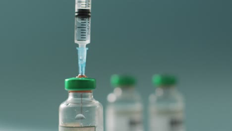 Video-Einer-Nahaufnahme-Von-Impfstofffläschchen-Auf-Grünem-Hintergrund
