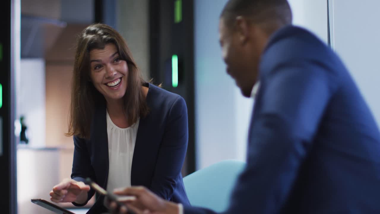 hombre de negocios y mujer de negocios sonrientes hablando en una oficina moderna