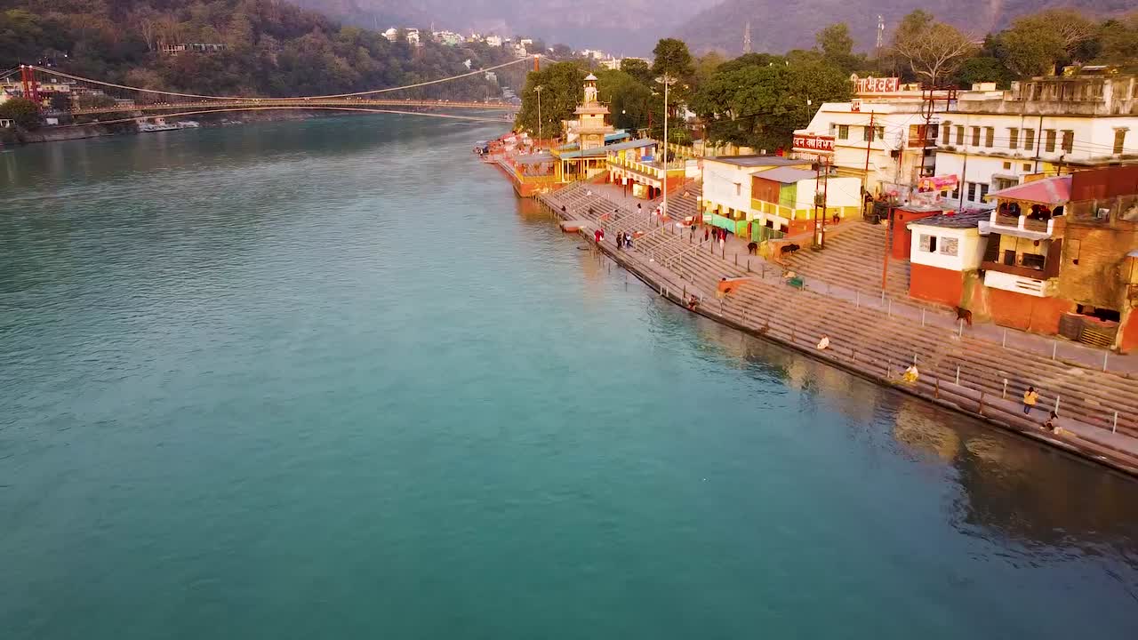 la orilla del río sagrado ganges llena de templos religiosos al atardecer se toma un video aéreo en rishikesh uttrakhand india el 15 de marzo de 2022