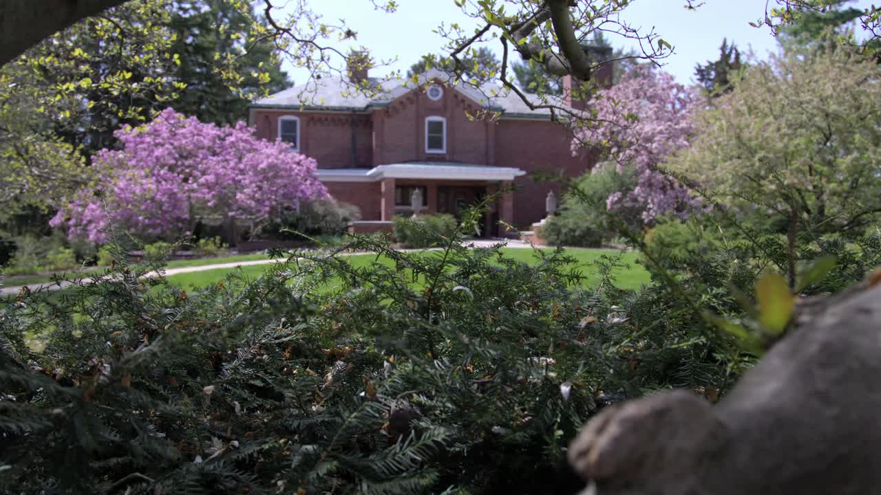 Cowles House during spring on the campus of Michigan State University in East Lansing, Michigan with gimbal video moving up.