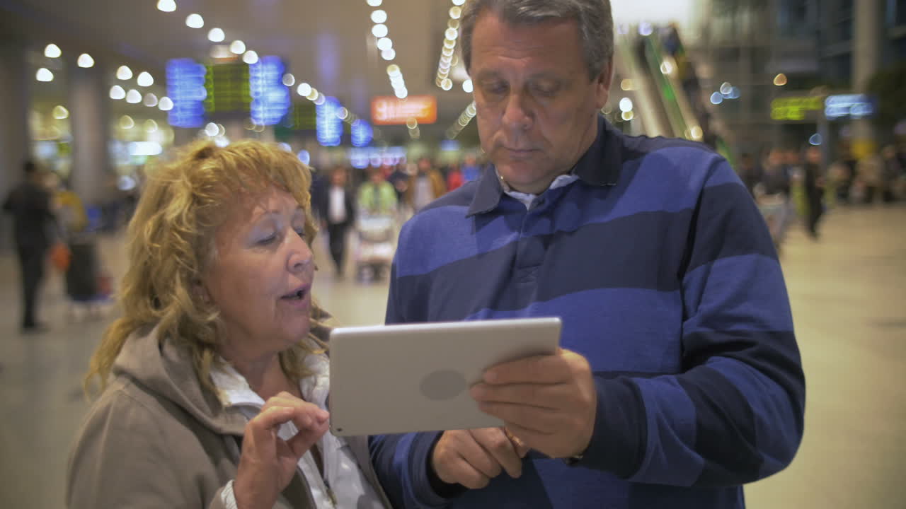 Coppia anziana con tablet all'aeroporto