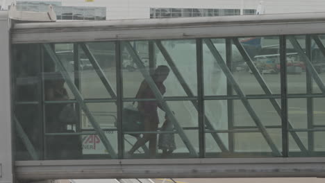 passengers exiting airplane using the sky bridge