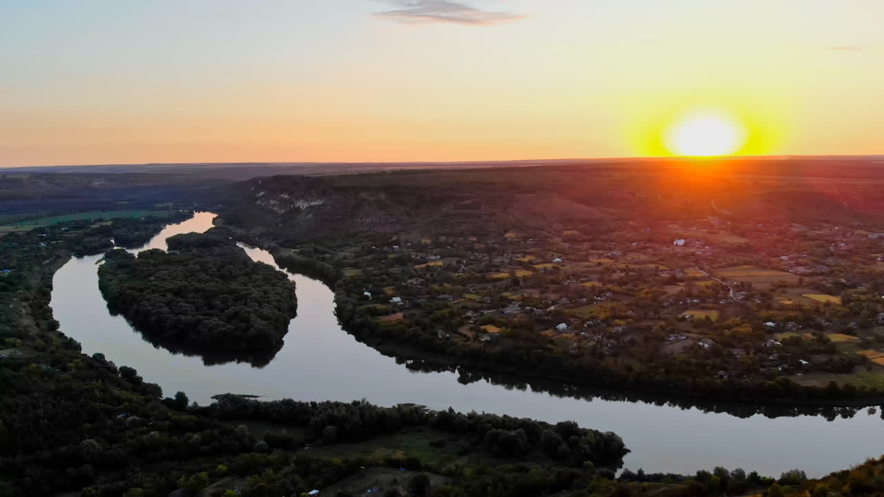 Vista aérea de un dron de un pueblo entre la vegetación en Moldavia. Lago y colinas verdes. Vista panorámica. Atardecer rojo