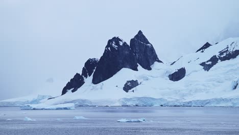 antártida invierno montañas en la costa, paisaje costero en la península antártica, escena azul fría con hielo de glaciar y agua de mar del océano sur, paisaje marítimo de montaña en una hermosa escena dramática