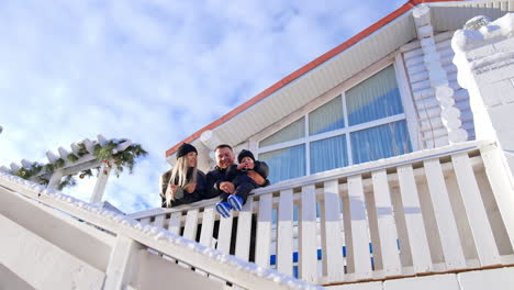 beautiful caucasian parents with toddler baby boy are outdoors in winter. happy family enjoys sunny day together. low angle view.
