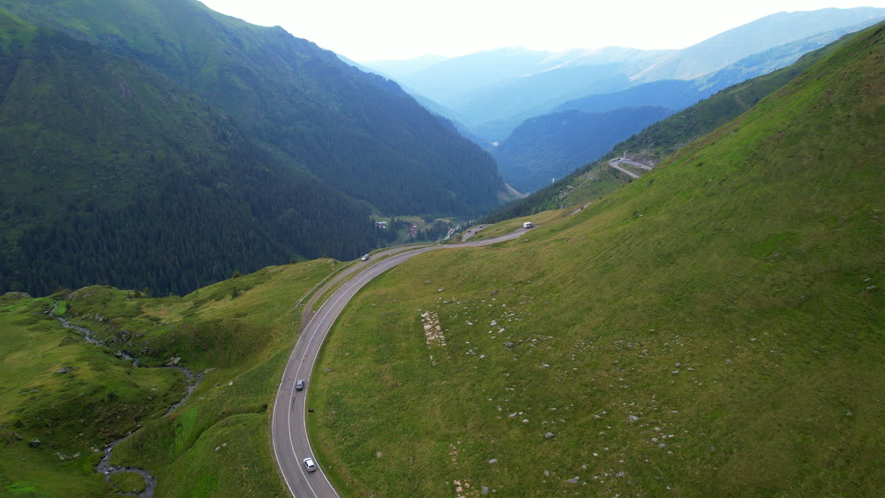 Picturesque alpine scene of vehicles driving though Transfagarasan road, Aerial