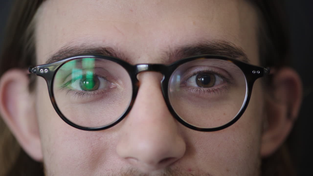 primer plano de un joven ojos con gafas lindo geek caucásico mirando a la cámara visión de la vista