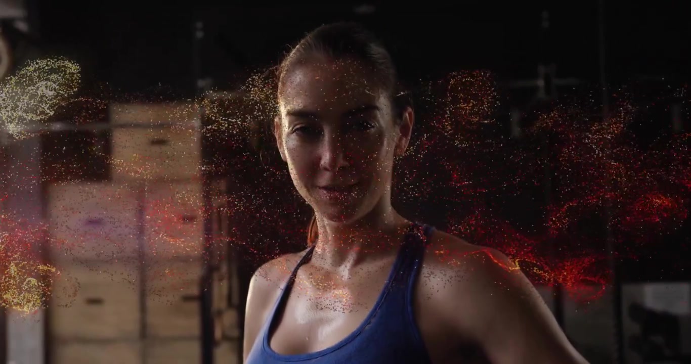 Atleta fitness donna di mezza età che espira vicino a un plyo box, alimentando particelle luminose che tracciano il busto