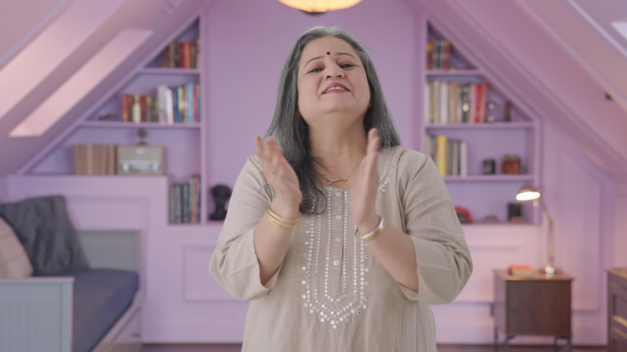 una anciana india feliz aplaudiendo y apreciando