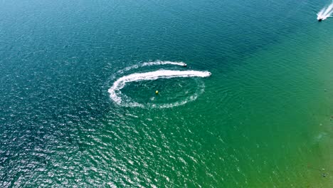 4k drone clip of boats and jet skis performing water sports next to an exotic beach in sveti vlas, bulgaria