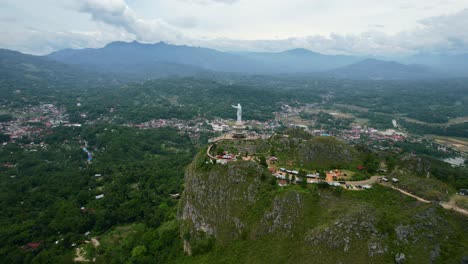 Antena-De-Una-Estatua-De-Jesucristo-En-Tana-Toraja-Sulawesi-En-La-Cima-De-Una-Montaña-Con-Turistas-Y-Tiendas