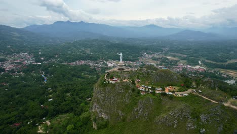 antena de una estatua de jesucristo en tana toraja sulawesi en la cima de una montaña con turistas y tiendas