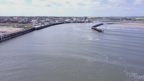 vista aérea que se eleva desde el nivel del río hacia el puerto en amble en northumberland, reino unido, desde la desembocadura del río