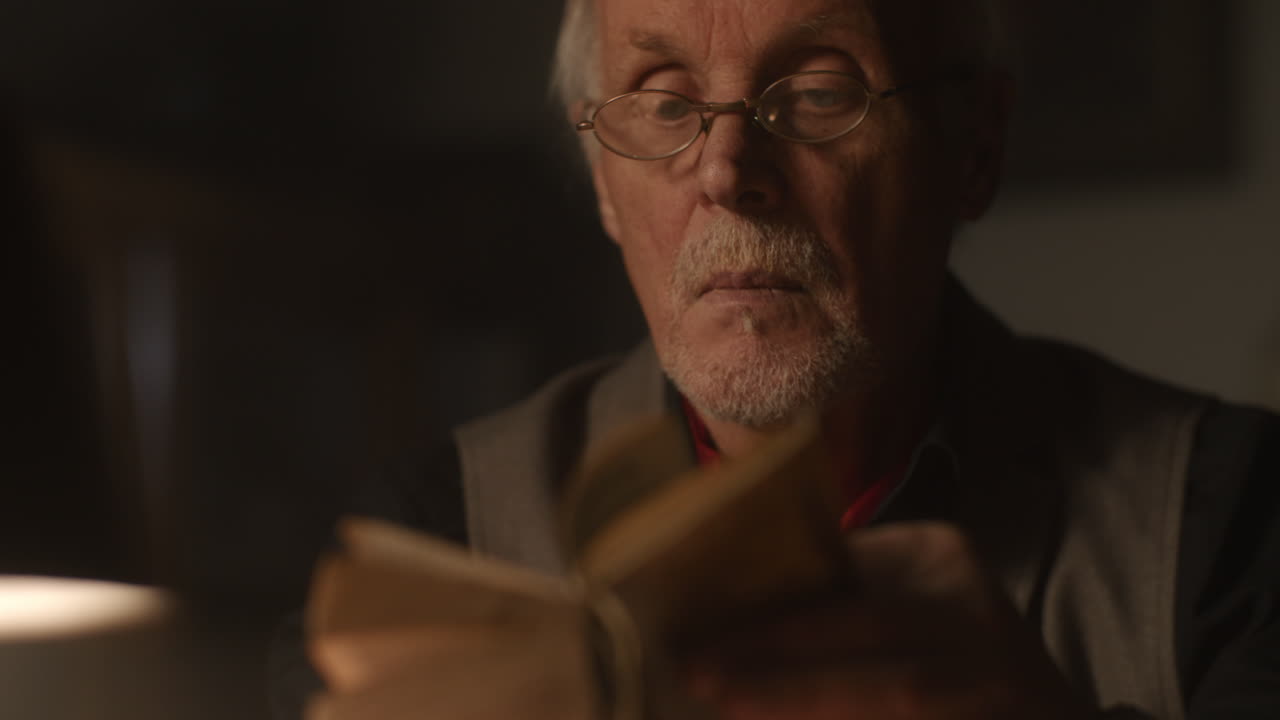 Old passionate man read a book in his office at night