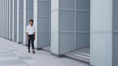 successful indian businessman walks confident towards camera against office