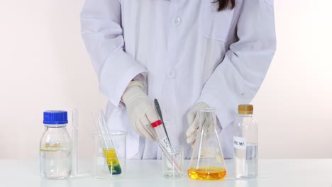 el científico lleva a cabo un colorido experimento de reacción química