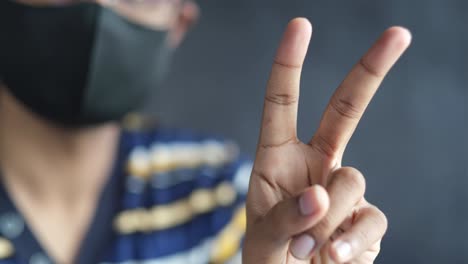 person making a peace sign with a mask